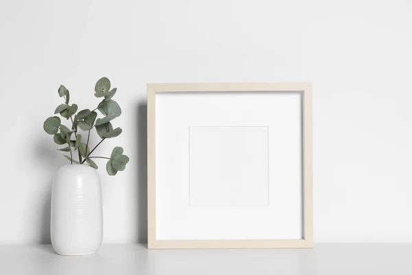 Üres Képkeret Váza Dekoratív Eukaliptusz Levelekkel Fehér Asztalon Mockup Tervezéshez — Stock Fotó
