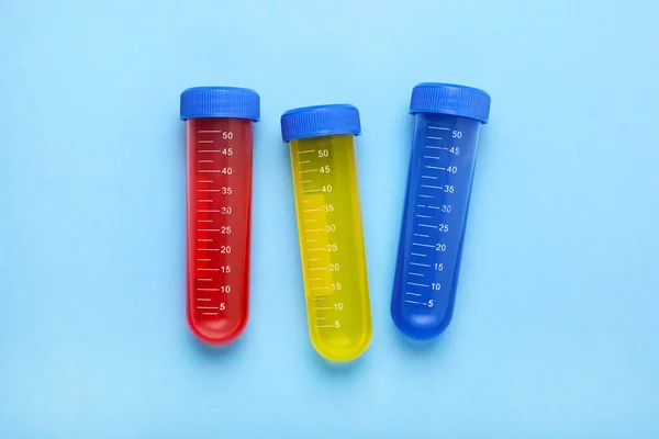 试管与五彩缤纷的液体在浅蓝色的背景上 平坦平铺 儿童化学实验集 — 图库照片