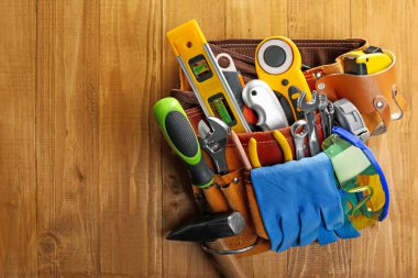 Üzerinde farklı aletler olan kemer, ahşap masa, üst manzara. Metin için boşluk