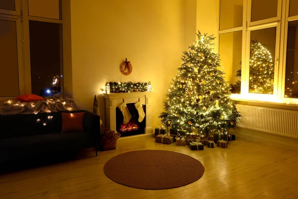 居心地の良い部屋でクリスマスツリー ソファ アクセサリーの近くのスタイリッシュな暖炉 — ストック写真