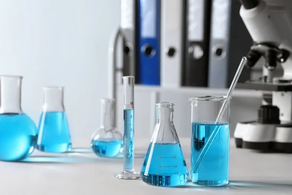 Diferentes Cristalería Laboratorio Con Líquido Azul Claro Mesa — Foto de Stock