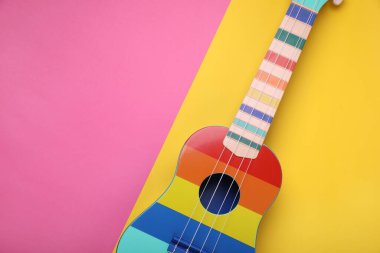 Renk arkaplanı üzerinde parlak ukulele, metin için üst görünüm ve boşluk. String müzik aleti