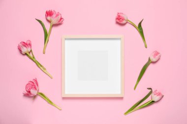Boş fotoğraf çerçevesi ve pembe arka planda güzel çiçekler. Tasarım için boşluk