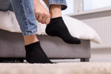 Evde siyah çorap giyen bir adam, yakın plan.