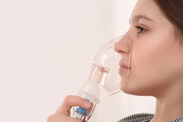Gadis Manis Menggunakan Nebulizer Untuk Menghirup Pada Latar Belakang Putih — Stok Foto