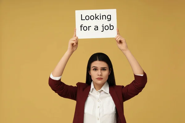 失业问题 不快乐的女人拿着标语牌 带着浅橙色背景的求职标语 — 图库照片