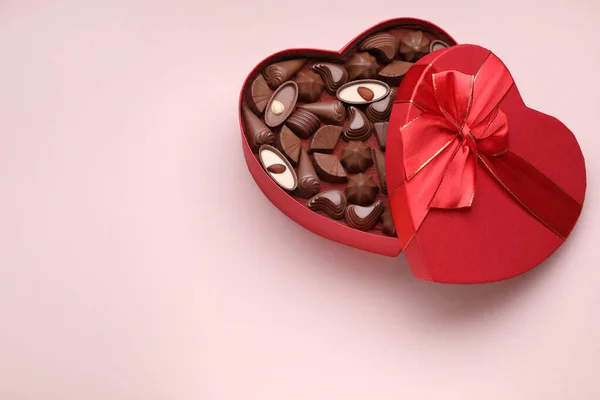 Hjärtformad Låda Med Läckra Chokladgodis Blekrosa Bakgrund Ovanifrån Plats För — Stockfoto