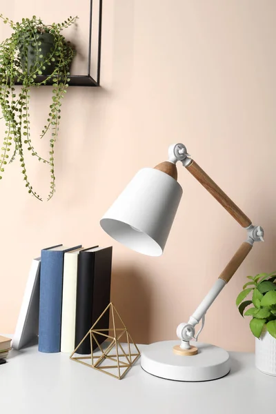 Stylish Modern Desk Lamp Books Plant Table Beige Wall Indoors — Stock Photo, Image