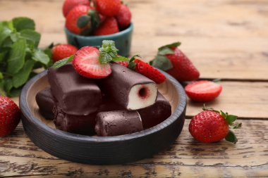 Lezzetli kremalı aperatifler taze çilekler ve ahşap masada nane şekeri.