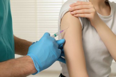 Doktor klinikteki hastaya hepatit aşısı veriyor.