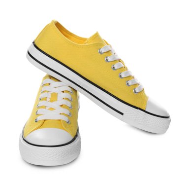 Beyaz arka planda bir çift sarı klasik eski moda spor ayakkabı.