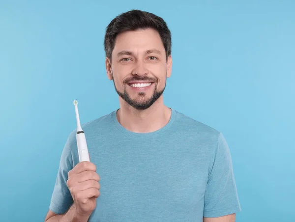 Homem Feliz Segurando Escova Dentes Elétrica Fundo Azul Claro — Fotografia de Stock