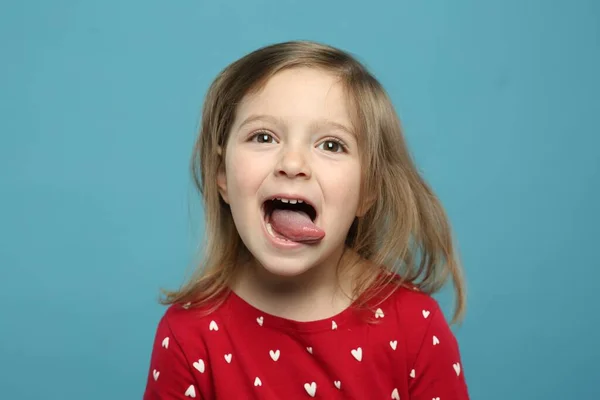 Lustiges Kleines Mädchen Zeigt Ihre Zunge Auf Hellblauem Hintergrund — Stockfoto