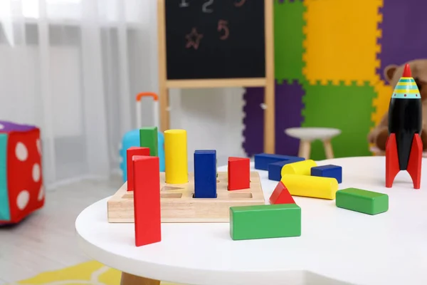 幼稚園の白いテーブルの上のさまざまなおもちゃ — ストック写真