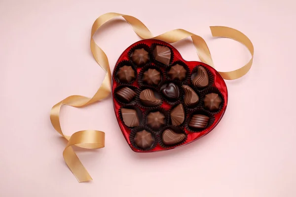 Caixa Forma Coração Com Deliciosos Doces Chocolate Fita Fundo Rosa — Fotografia de Stock