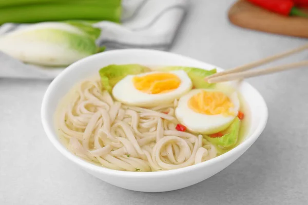 Bowl Delicious Rice Noodle Soup Celery Egg Light Grey Table — Stock Photo, Image