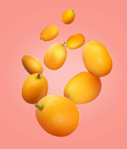 Deliciosos Kumquats Frescos Caindo Sobre Fundo Rosa — Fotografia de Stock