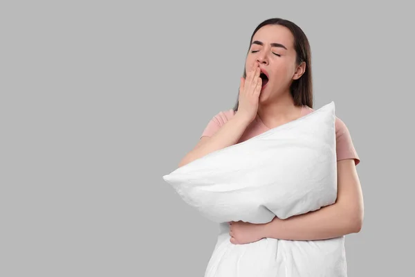 薄い灰色の背景に枕のあくびをすると疲れて若い女性は テキストのためのスペース 不眠症の問題 — ストック写真