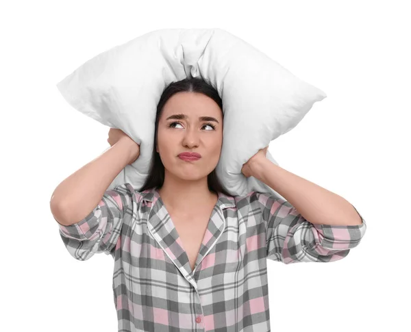 stock image Tired young woman covering ears with pillow on white background. Insomnia problem