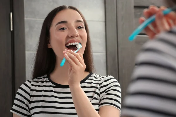 Mladá Žena Čištění Zubů Plastovým Zubním Kartáčkem Blízkosti Zrcadla Koupelně — Stock fotografie