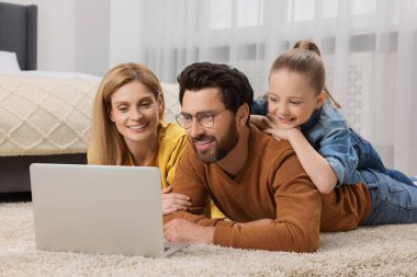 Evde dizüstü bilgisayarı olan mutlu bir aile
