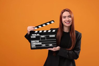 Turuncu arka planı olan mutlu bir aktris. Film endüstrisi