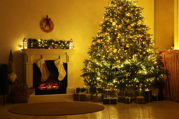 装饰圣诞树附近的时尚壁炉和舒适房间里的装饰品 — 图库照片