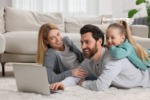 自宅で床にノートパソコンを持つ幸せな家族 — ストック写真