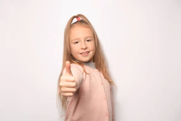快乐的小女孩在白色的背景上竖起大拇指 — 图库照片