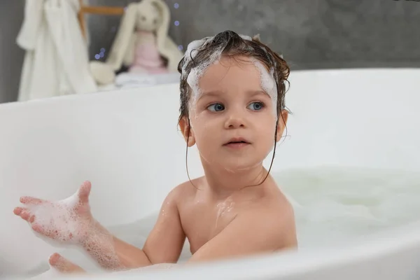 可爱的小女孩在浴室用洗发水洗头发 — 图库照片