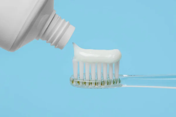 Elektryczna Szczoteczka Zębów Pastą Jasnoniebieskim Tle Zbliżenie — Zdjęcie stockowe