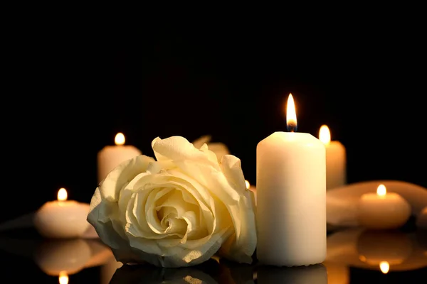 白色的玫瑰和燃烧的蜡烛在黑暗的黑色镜子表面 与文字的空间紧密相连 丧葬标志 — 图库照片