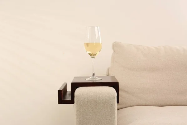 木製のアームレストテーブルを屋内でソファの上に白ワインのガラス 内装要素 — ストック写真