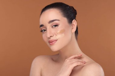 Esmer arkaplanda fondöten örnekleri olan bir kadın.