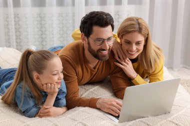 Mutlu aile ile evde yatak üstünde laptop