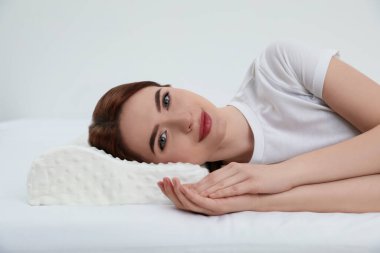 Beyaz arka planda köpük yastıkta yatan kadın