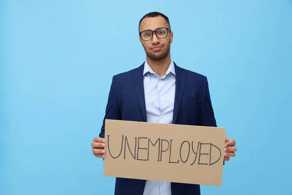 拿着标语牌 浅蓝色背景失业的年轻人 — 图库照片