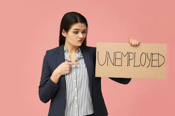 拿着写着 失业粉色背景 字样的不快乐女人 — 图库照片