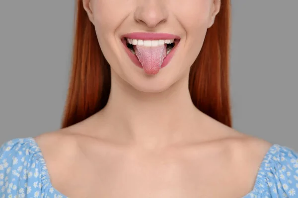 Šťastná Žena Ukazuje Svůj Jazyk Šedém Pozadí Detailní Záběr — Stock fotografie