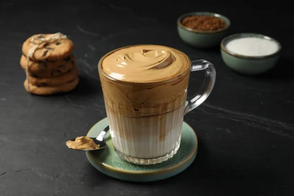 濃いテーブルの上においしいダルゴナコーヒーのグラスマグカップ — ストック写真