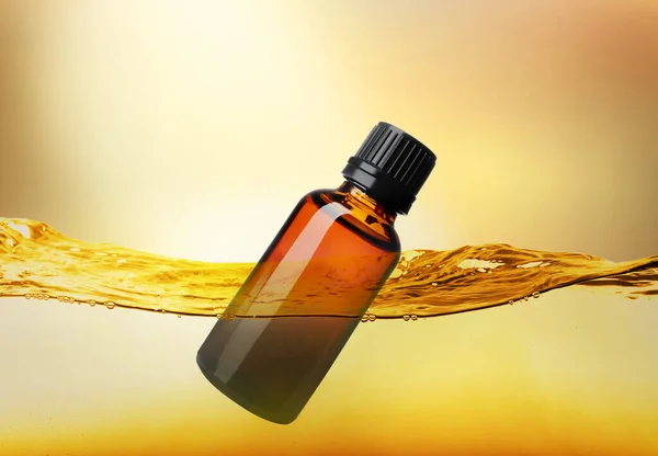 Fles Cosmetisch Product Drijvend Etherische Olie Tegen Goud Gradiënt Achtergrond — Stockfoto