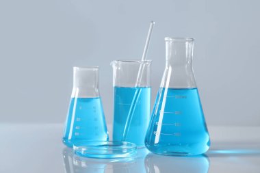 Masada açık mavi sıvı bulunan farklı bir laboratuar cam.