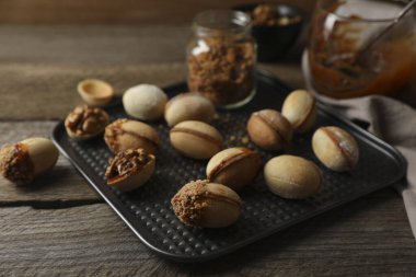 Yeni pişirilmiş ev yapımı ceviz şekilli kurabiyeler ahşap masada, yakın plan.