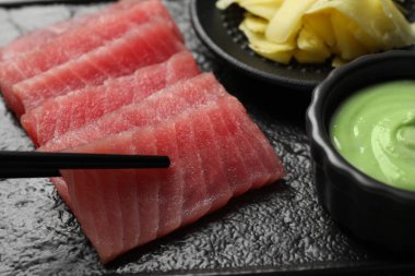 Siyah tabaktan lezzetli sashimi (taze çiğ ton balığı) alıyoruz, yakın plan.
