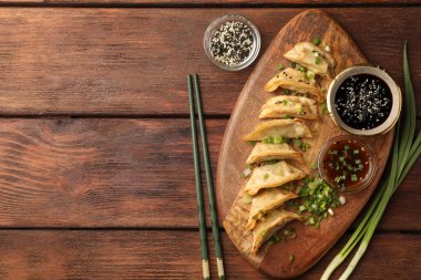 Lezzetli gyoza (Asya hamur tatlısı) ahşap masada servis edilir, düz yatar. Metin için boşluk