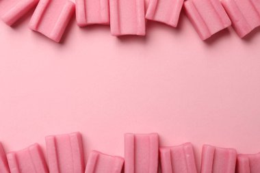 Tasty chewing gums on pink background, flat lay. Space for text