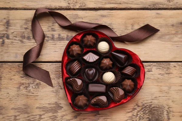 Caixa Forma Coração Com Deliciosos Doces Chocolate Fita Mesa Madeira — Fotografia de Stock
