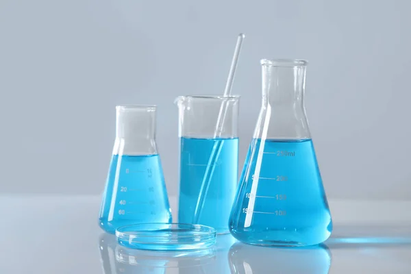 Vidros Laboratório Diferentes Com Líquido Azul Claro Mesa — Fotografia de Stock