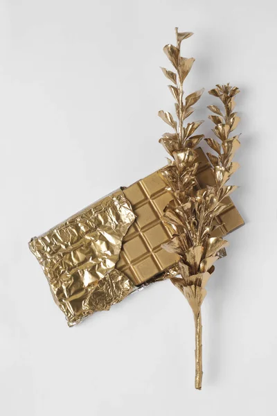 Brillante Elegante Barra Cioccolato Oro Ramo Con Foglie Sfondo Bianco — Foto Stock