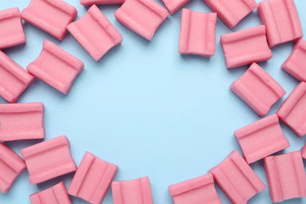 淡蓝色底色的美味粉红咀嚼牙龈框架 案文的篇幅 — 图库照片